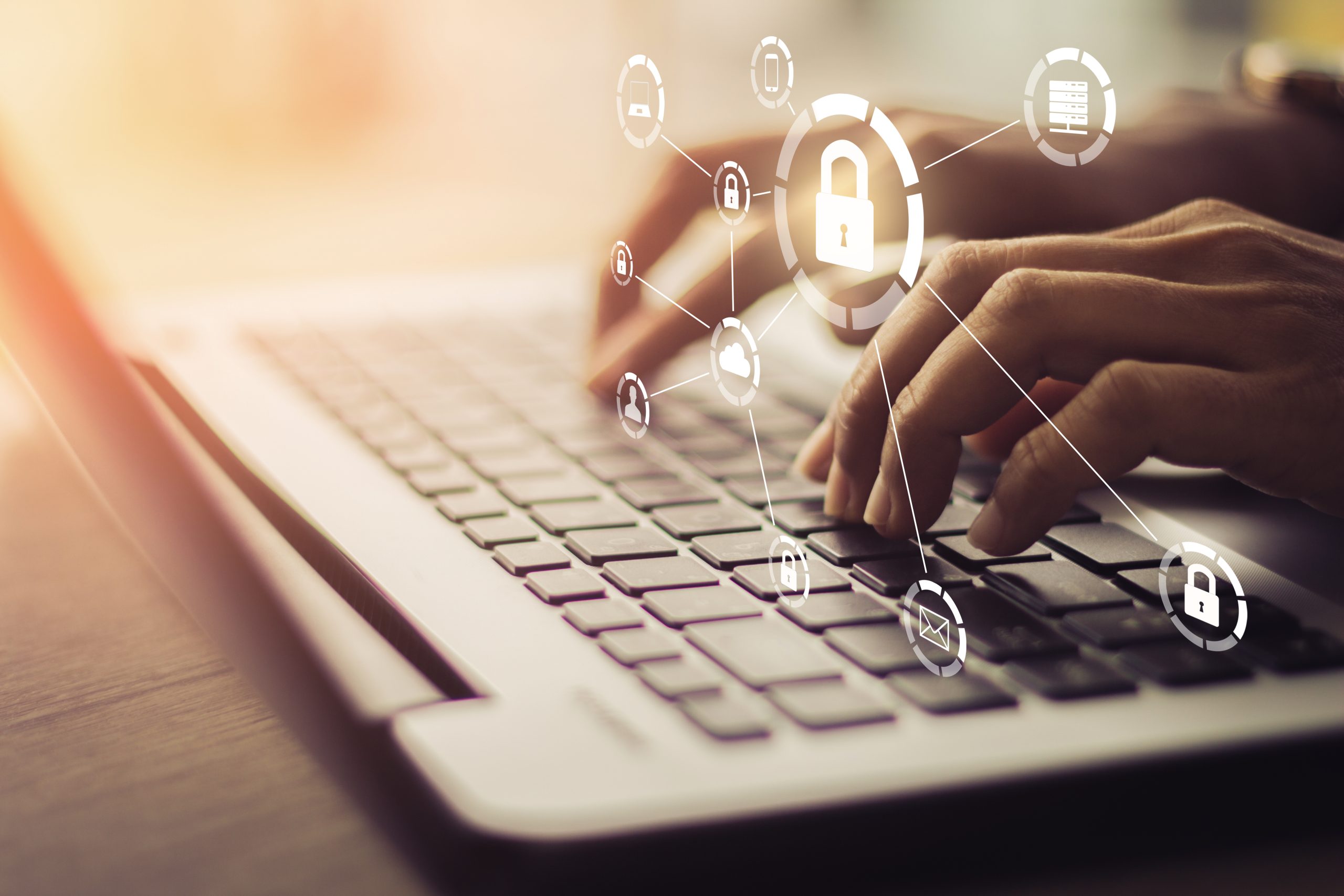 Close-up of hands typing on a laptop keyboard with digital security icons, including padlocks, cloud, email, and user symbols, overlaid to represent cybersecurity and data protection.